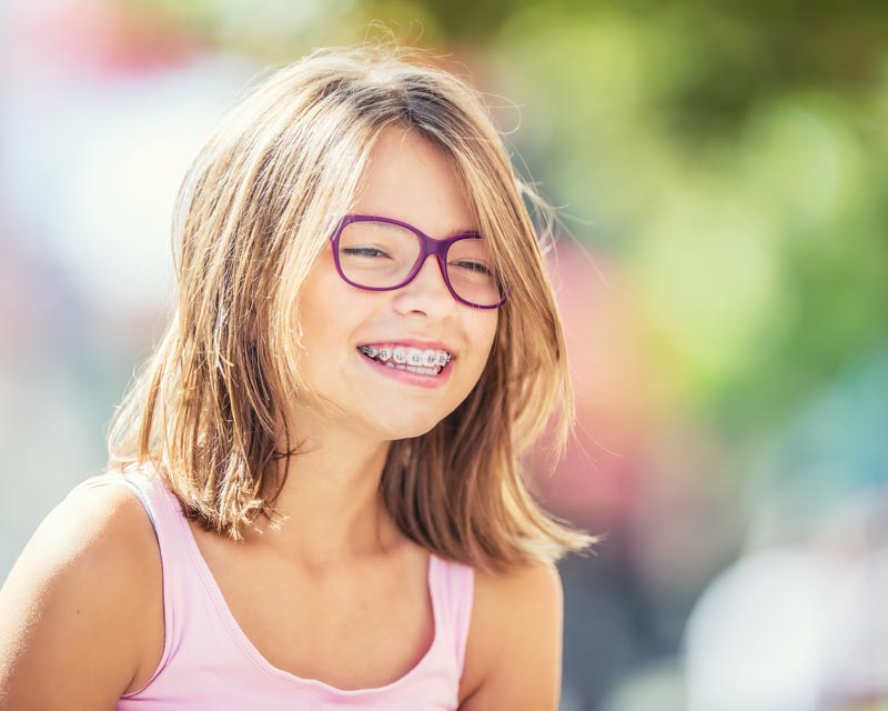 Metal braces patient outside Carmel, IN orthodontics office